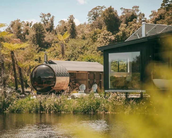 A view of Sunset Cabin with its sauna on the lakeside. It's one of the best romantic stays in New Zealand
