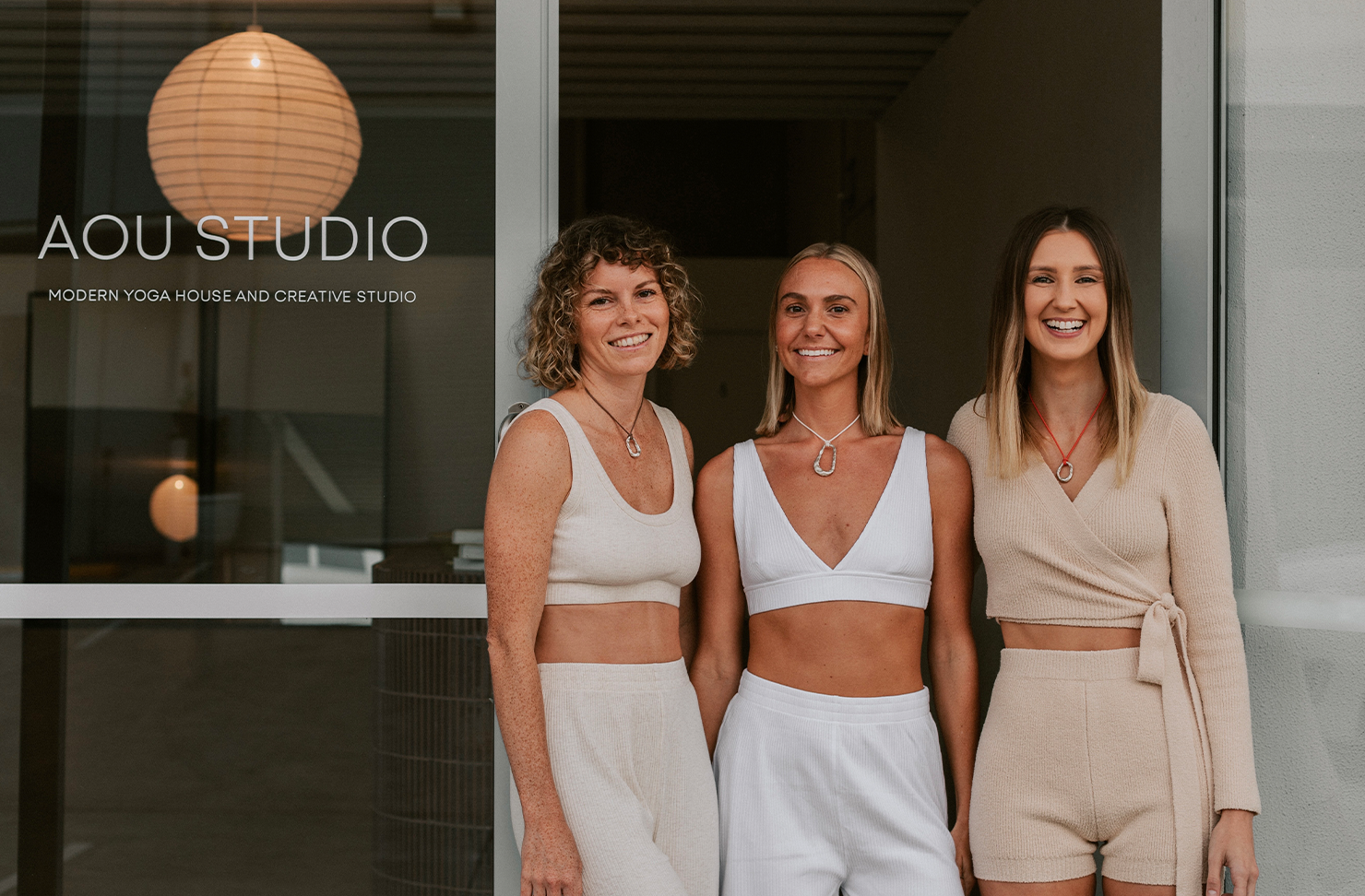 three women in front of a yoga studio