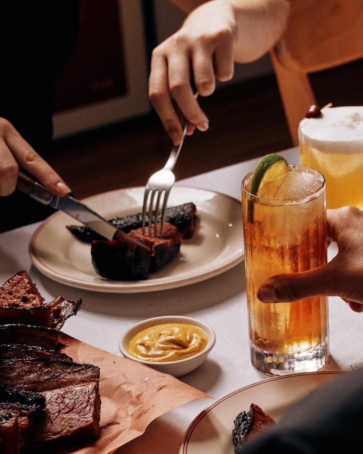 Enjoying a smoked meat with a Jim Beam cocktail