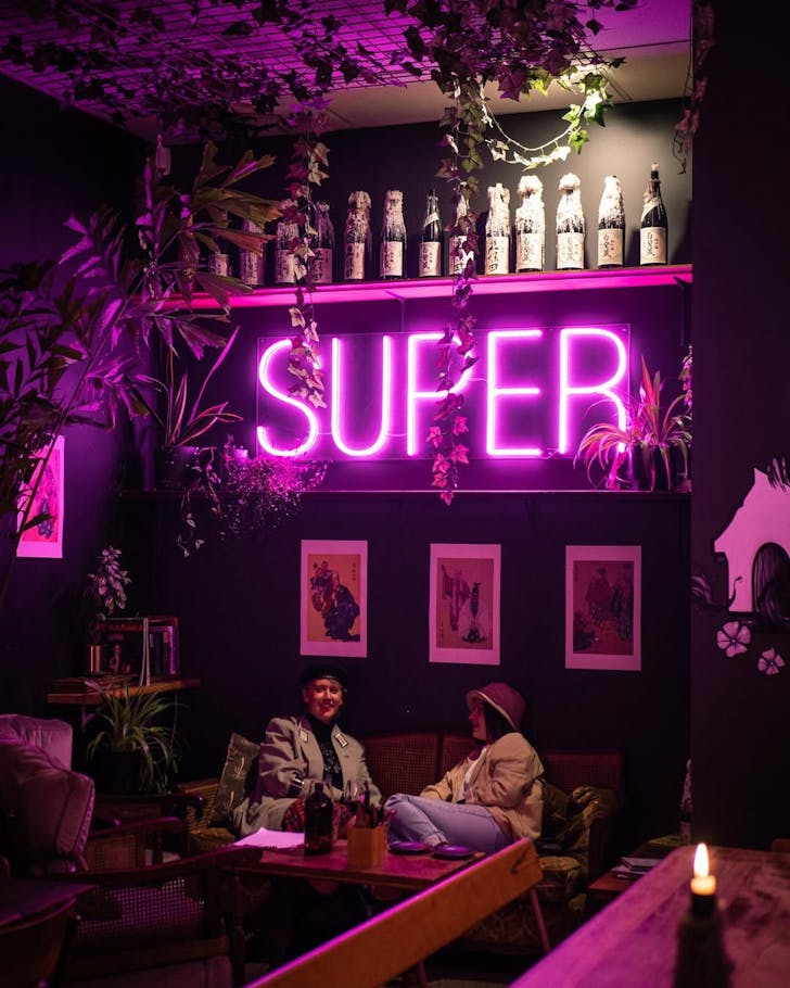 Two people enjoying the neon-lit surrounds at Super. 