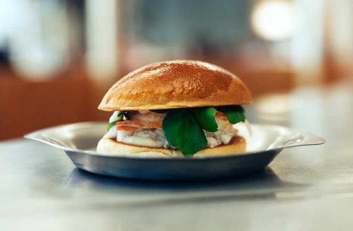 One of the best lobster roll Melbourne has on a metal tray with a blurred background.