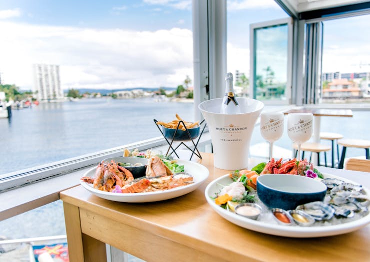 champagne and seafood on a table with waterfront views