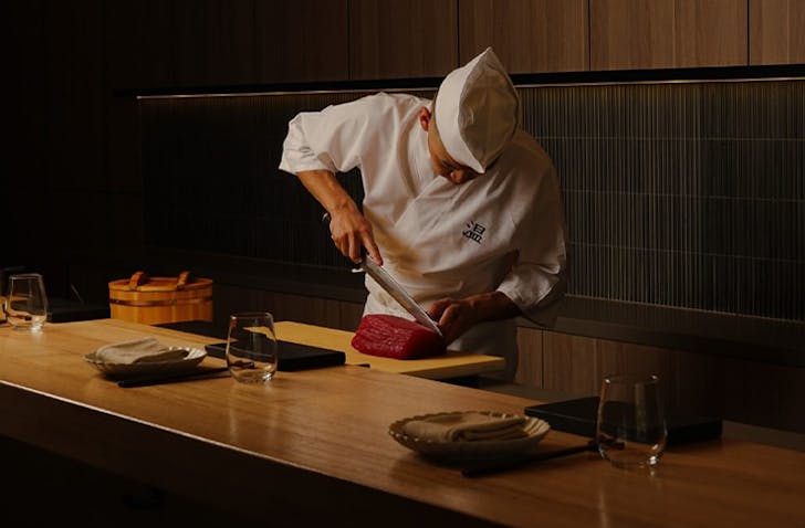 A expert Japanese chef is slicing meat at a chef's table experience at one of the best Japanese Melbourne spots called Sushi On.