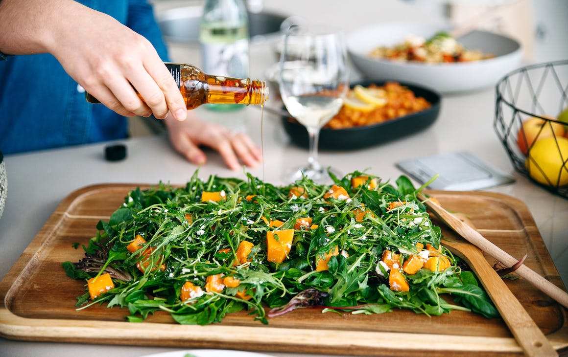 A green salad served on a wooden board.