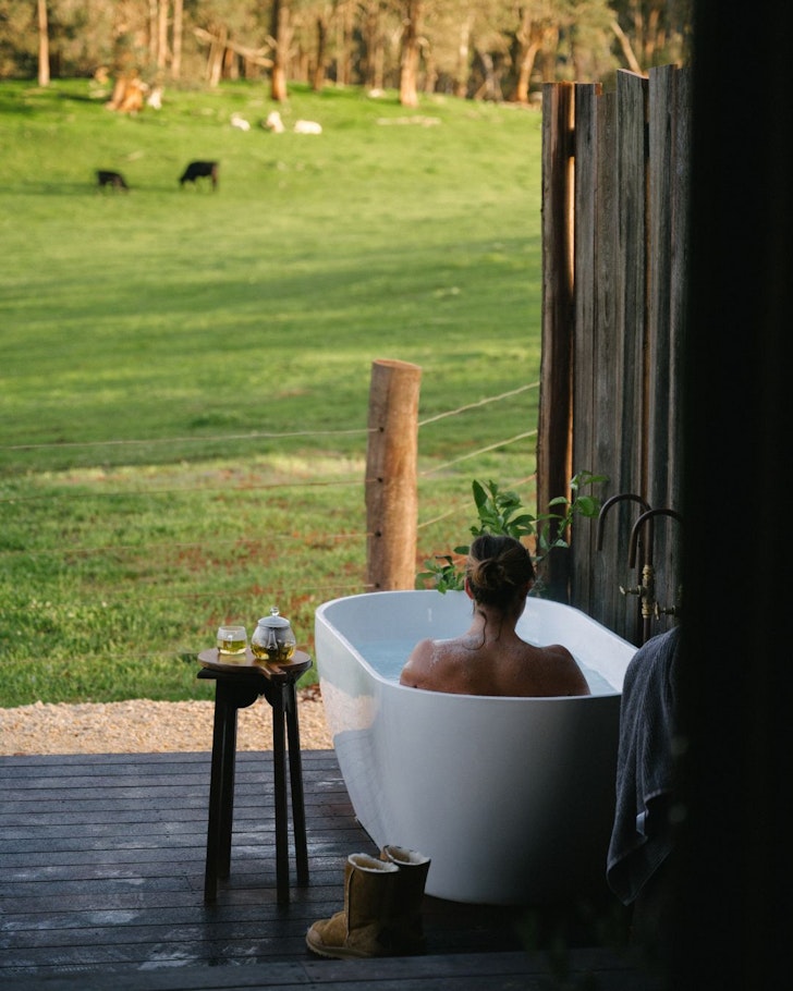 A woman in the outdoor bath at Sylvie's Hut one of the best WA farm stays