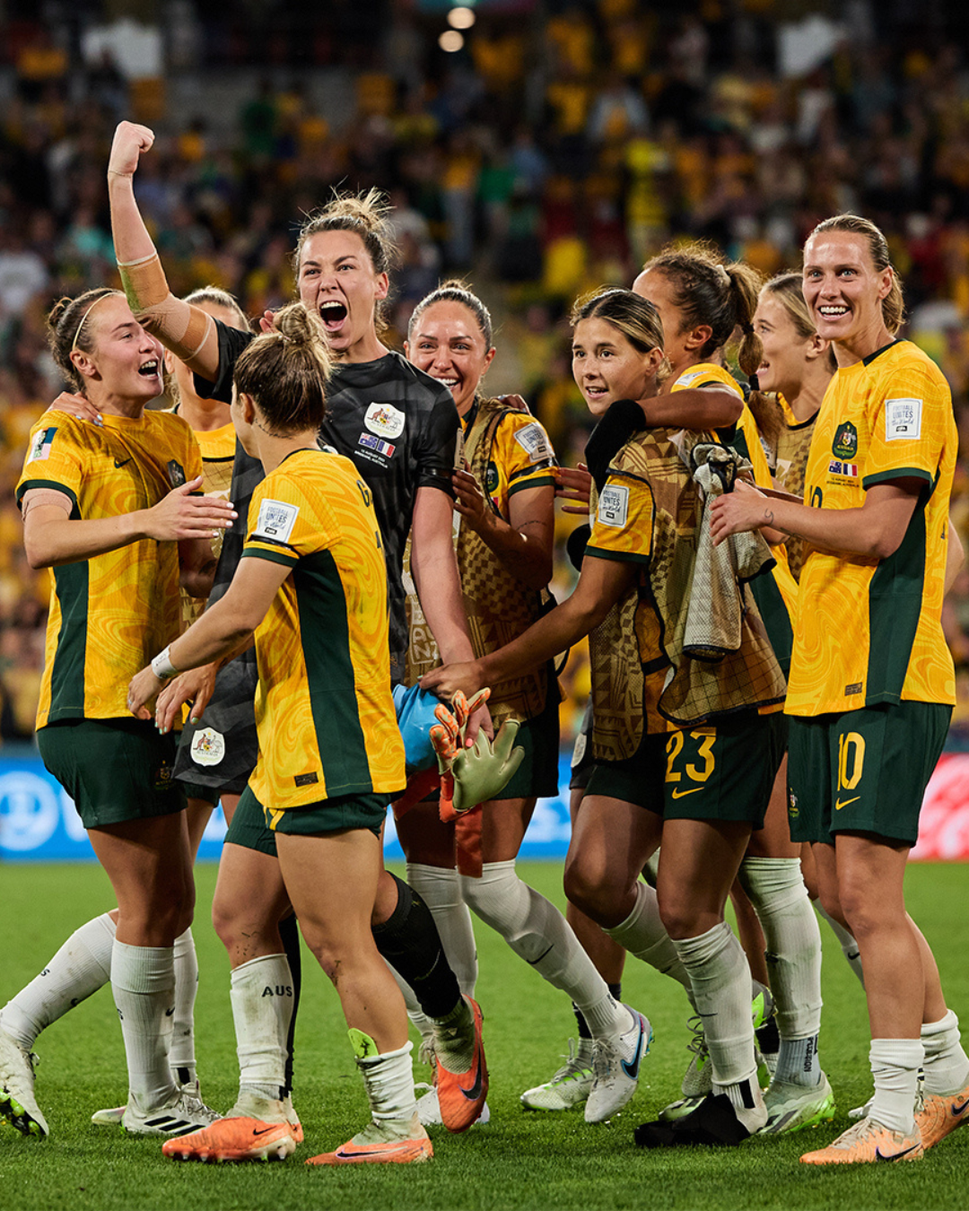 The Matildas celebrating on a football pitch