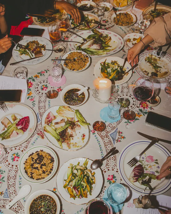 Table with plates and hands grabbing around
