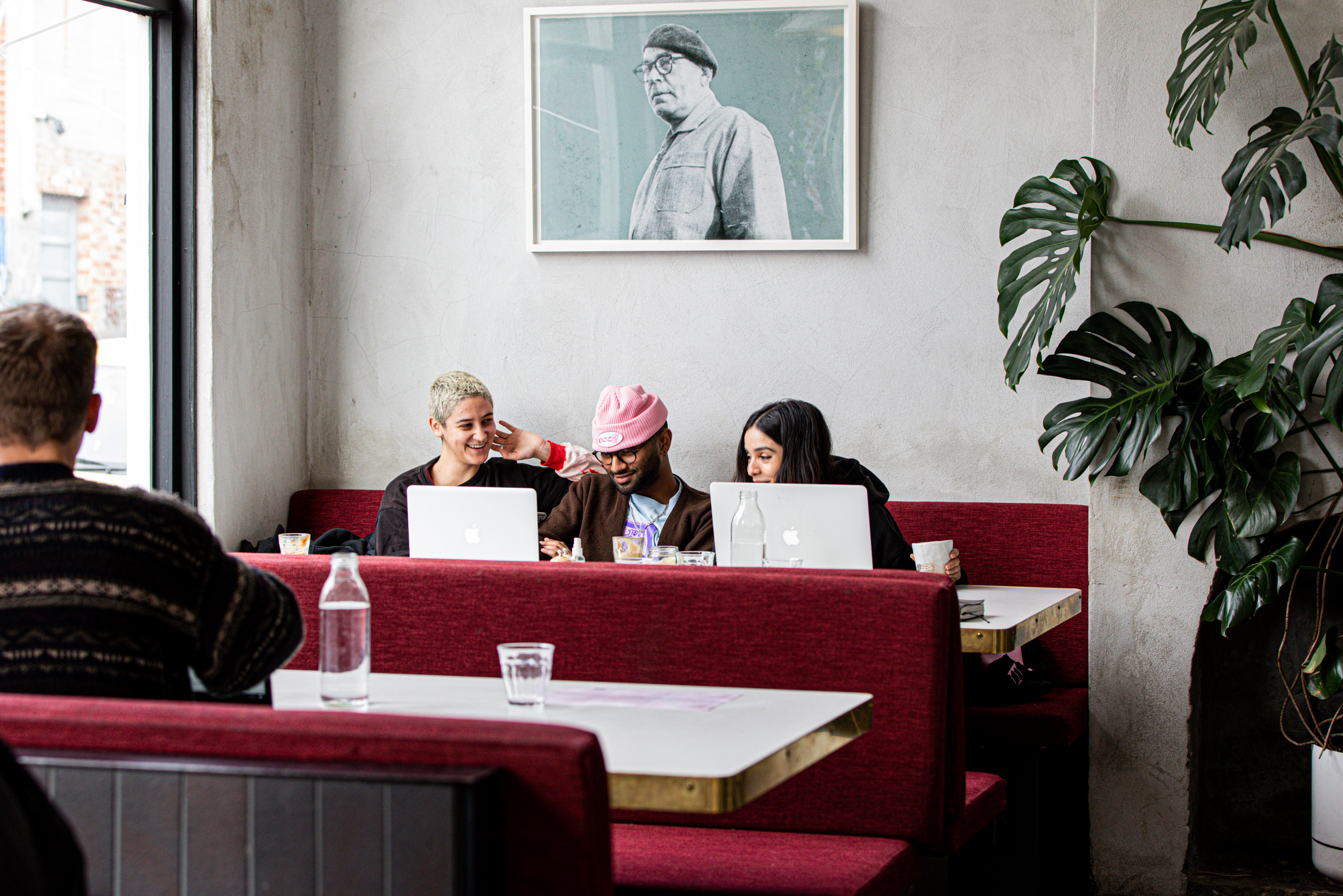 Three people sitting at a booth at one of the best cafes in Melbourne for 2023