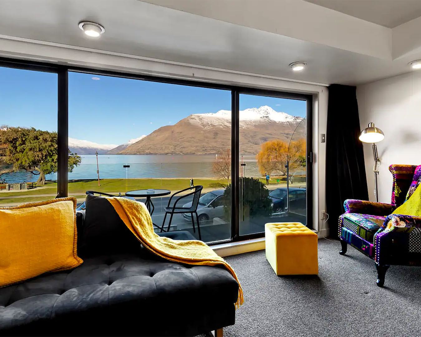 The Tahuna apartment shows a comfortable living room looking out onto a view of mountains and blue water.
