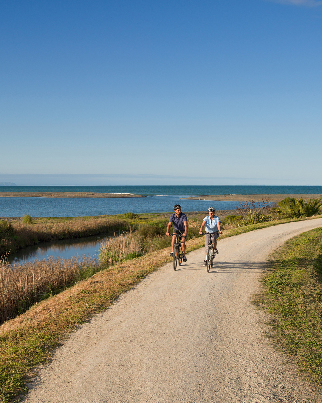 Two people cycling through Takaro Trails