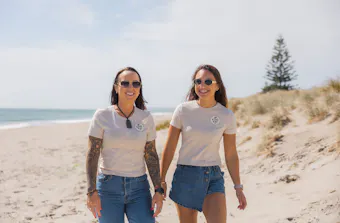 Tania and Shaianne walk along a beach together