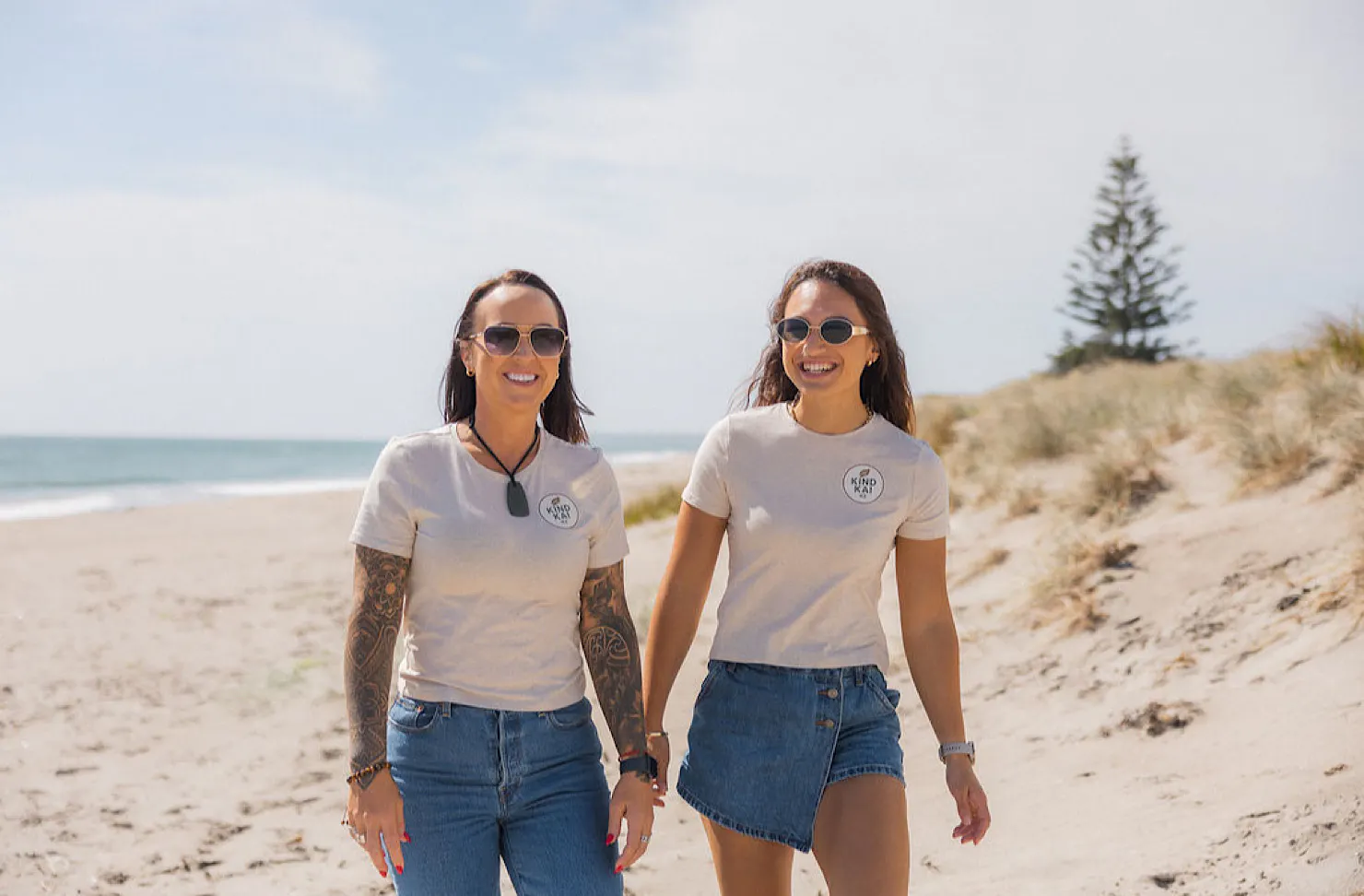 Tania and Shaianne walk along a beach together