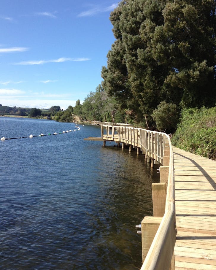 Boardwalk around the edge of a lake on a sunny day 