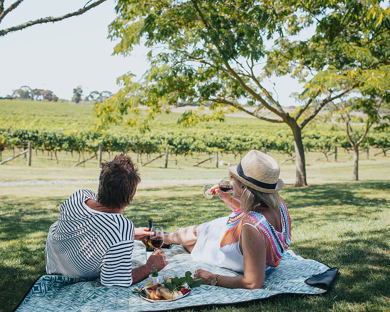 Two people enjoy a picnic with wine at Te Awanga Estate in Hawke's Bay.