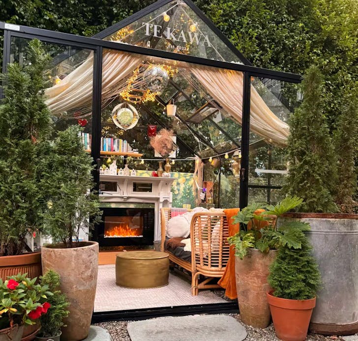 The glass house with a cosy couch at Te Kawa romantic Airbnb Auckland