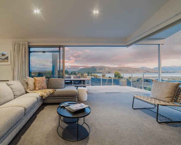 The epic living space at Tekapo 180 Degrees with glass doors that open to a view of Lake Tekapo and the mountains