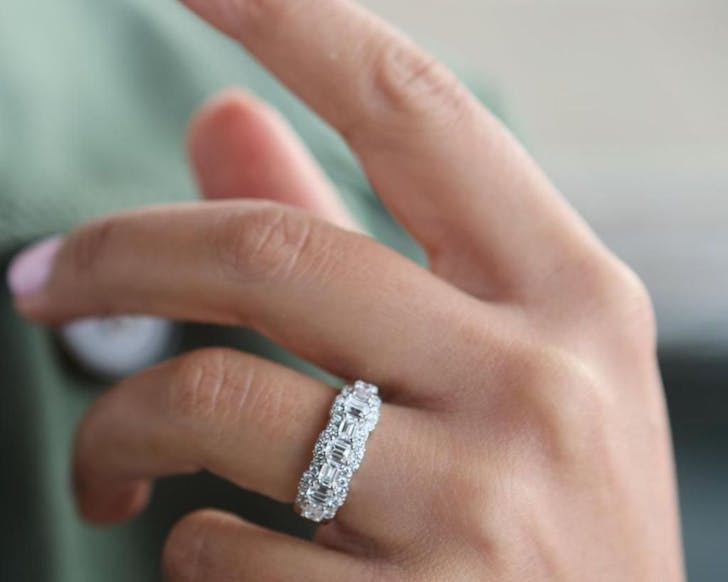 A close up of a Temple & Grace diamond wedding band on a woman's hand