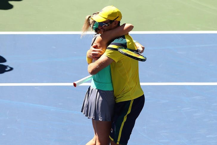 Two Australian tennis players hugging on court 