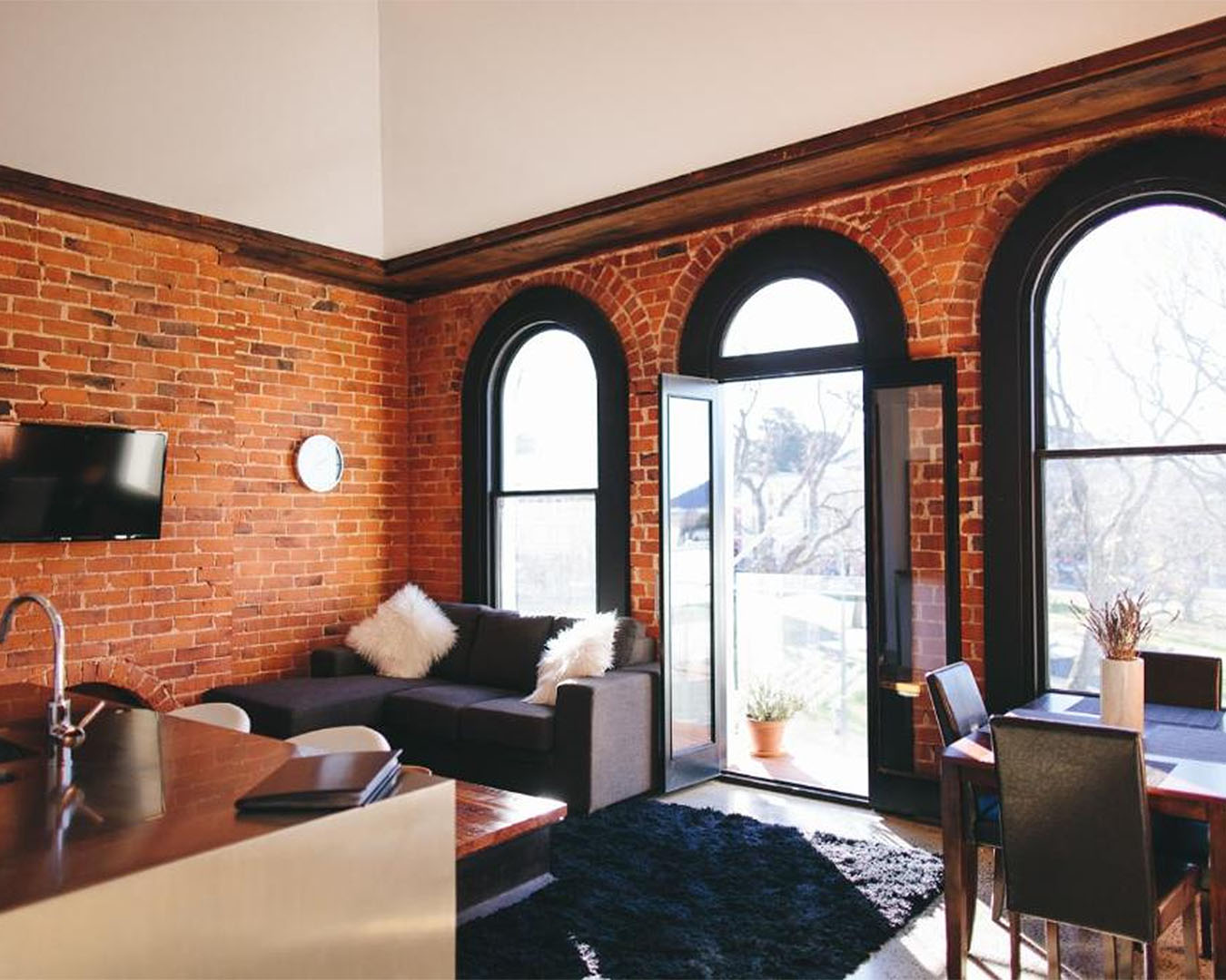 Wooden-accents and brick walls with vintage windows at Terminus Apartments in Dunedin.