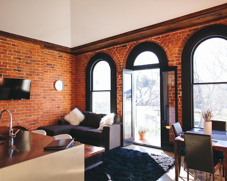 Wooden-accents and brick walls with vintage windows at Terminus Apartments in Dunedin.