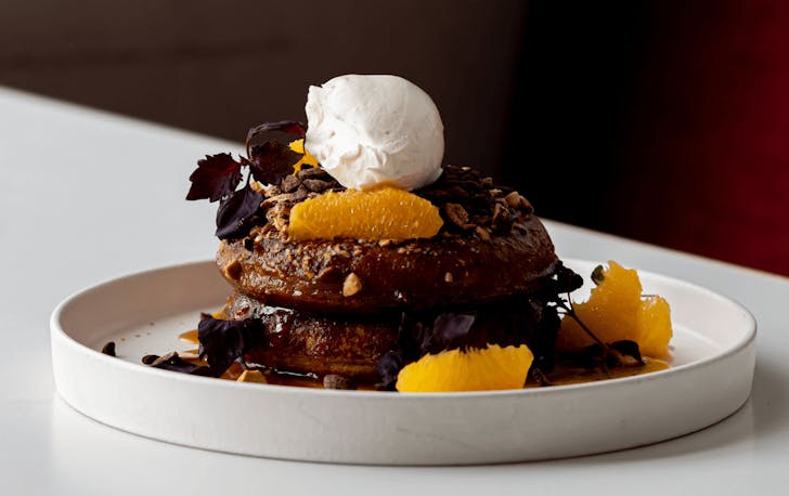 A mountain of chocolate fluffy pancakes topped with fresh fruit and nutsâone of the best breakfasts in Melbourne at Terror Twilight