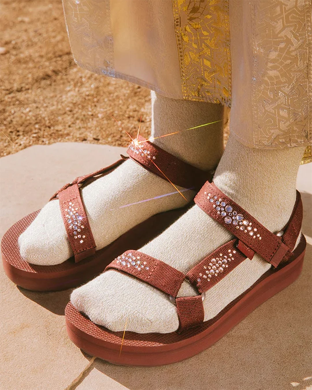 Someone wears cream socks with a new pair of Teva holiday sandals.