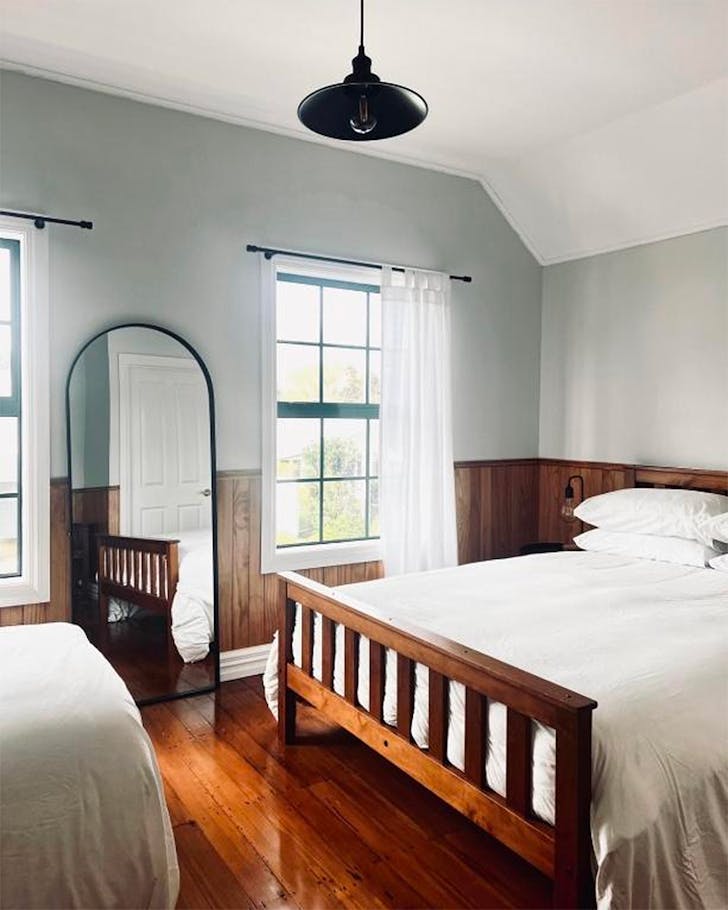 A minimalist bedroom with sleek wooden floors at The Åkato, one of the best hotels near New Plymouth. 