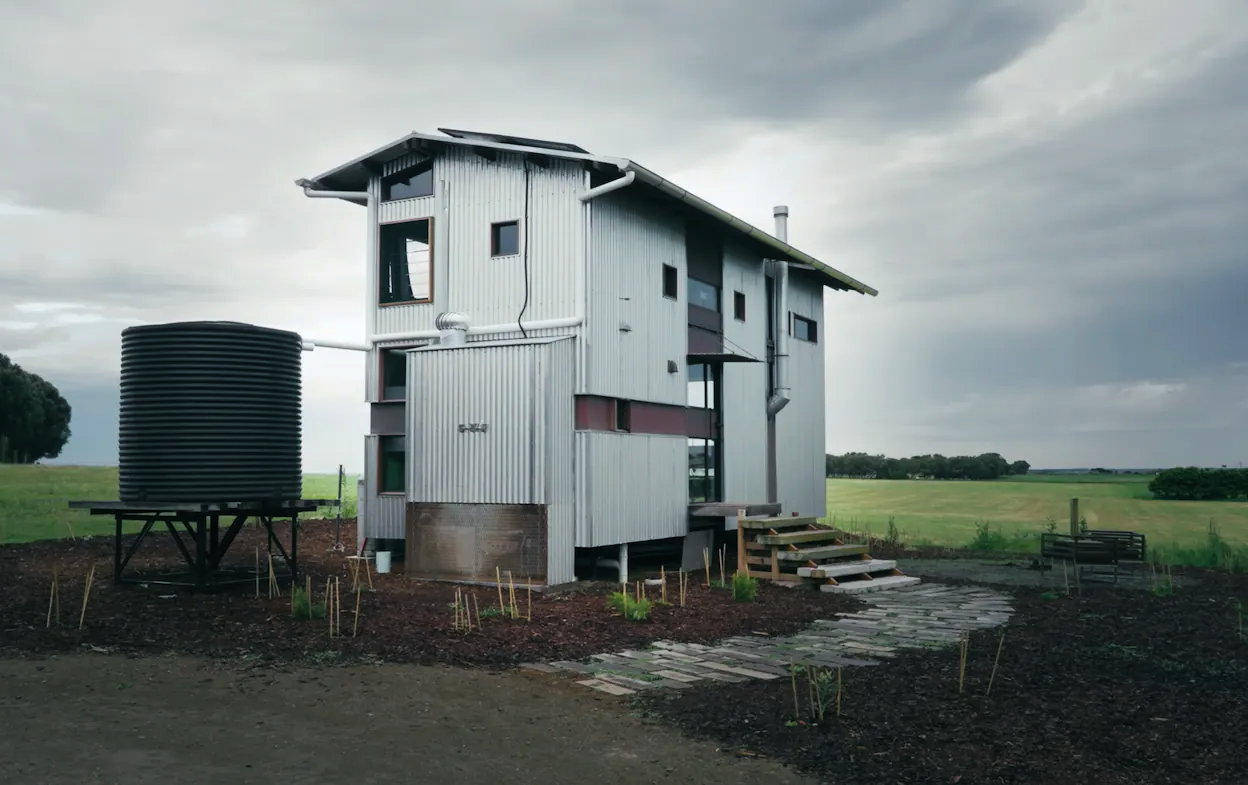 A large farm house with a water tank. 