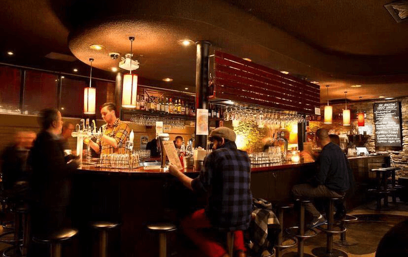 A curved bar with people drinking beer at the one of best pubs Melbourne is serving up in 2024.