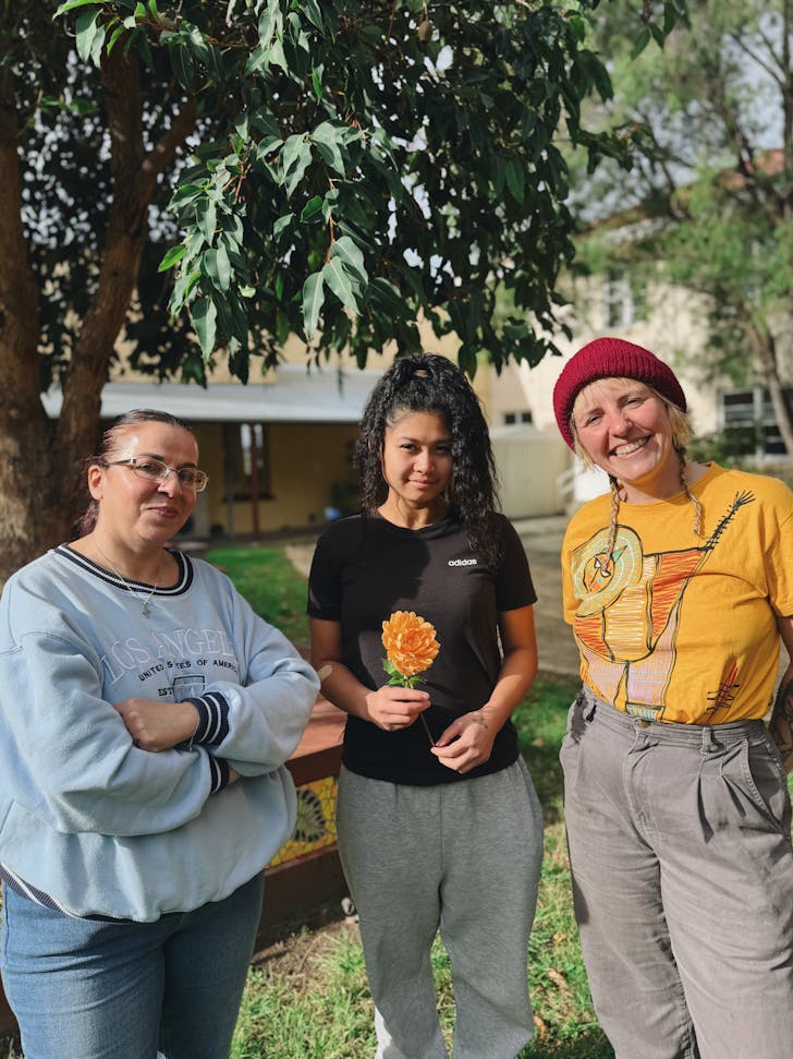 Three women standing smiling at the camera.