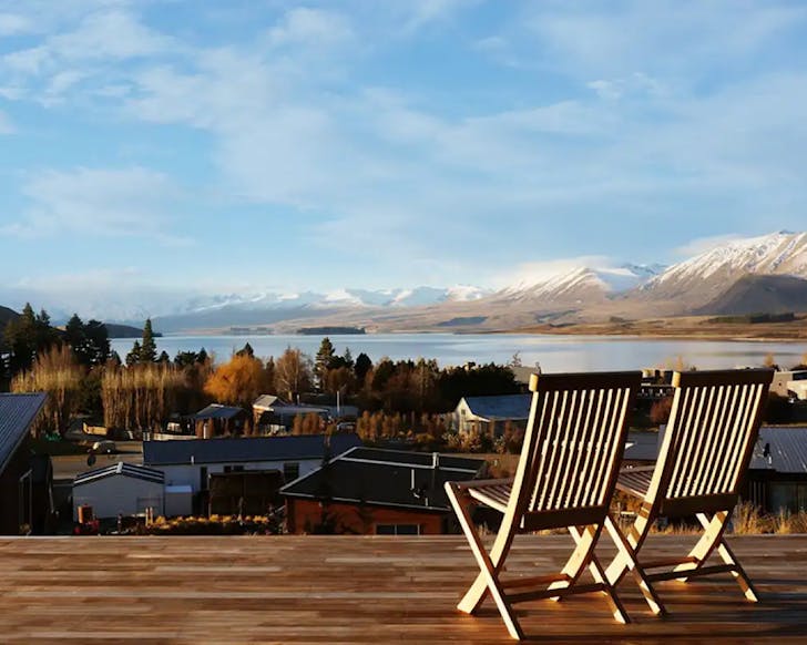 Two deck chairs on a slab deck overlooking a jaw-dropping view of Lake Tekapo. 