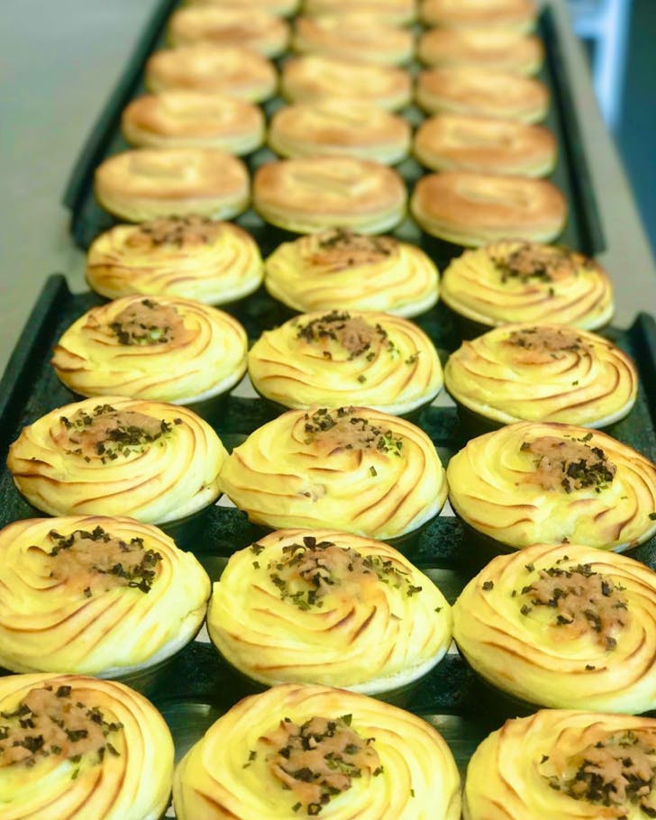 Trays of freshly-baked pies, some topped with a layer of dreamy mashed potato. 