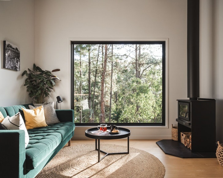 The living space with a view of trees at The Blak Shack best treehouse stays Queensland