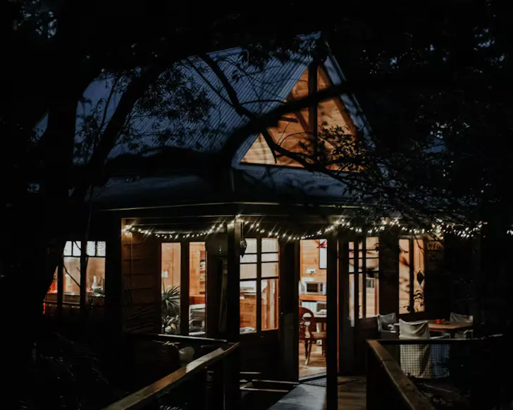 A view of The Bower Airbnb at night with its cosy lights on, it's one of the best romantic getaways in Australia