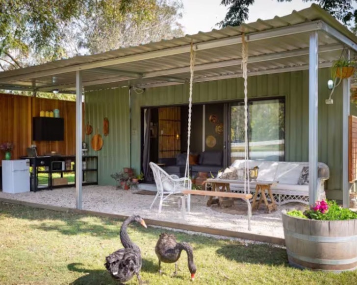 An exterior view of the green shipping container The Bungalow one of the best tiny home stays in South East Queensland