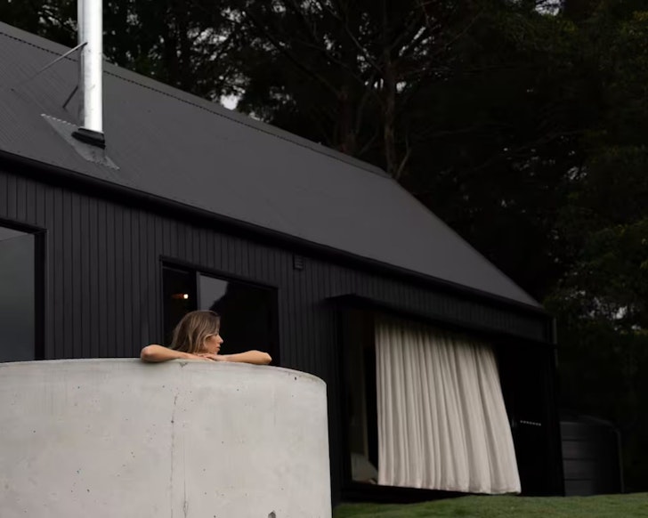 A guest soaks in the outdoor pool at The Cabin at Round Hill tiny home in South East Queensland