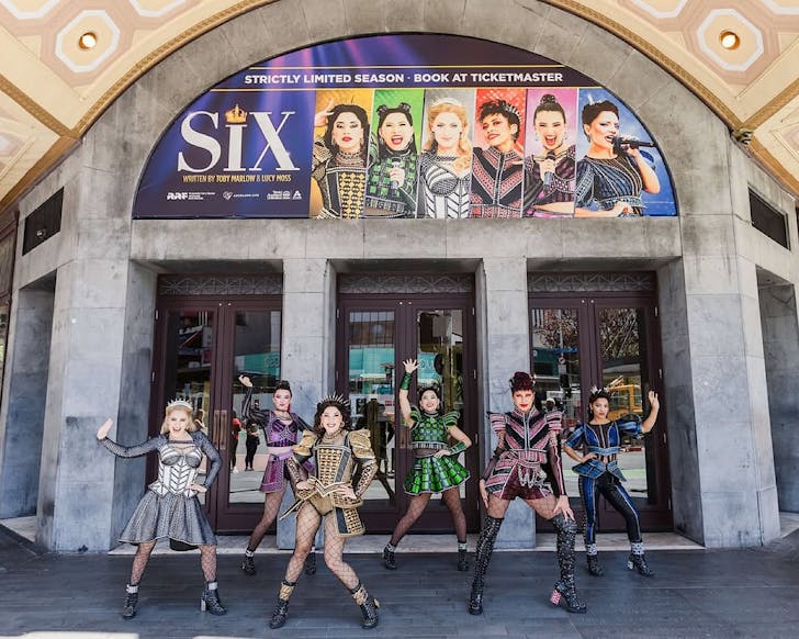 The leads in SIX The Musical pose in full costume outside the entrance to The Civic. 