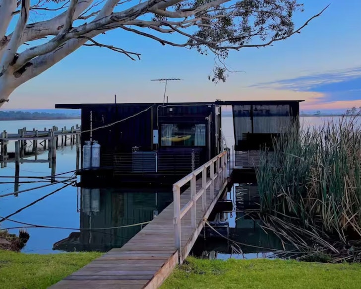 A view of The Cube floating on the water, one of the best tiny houses in Australia