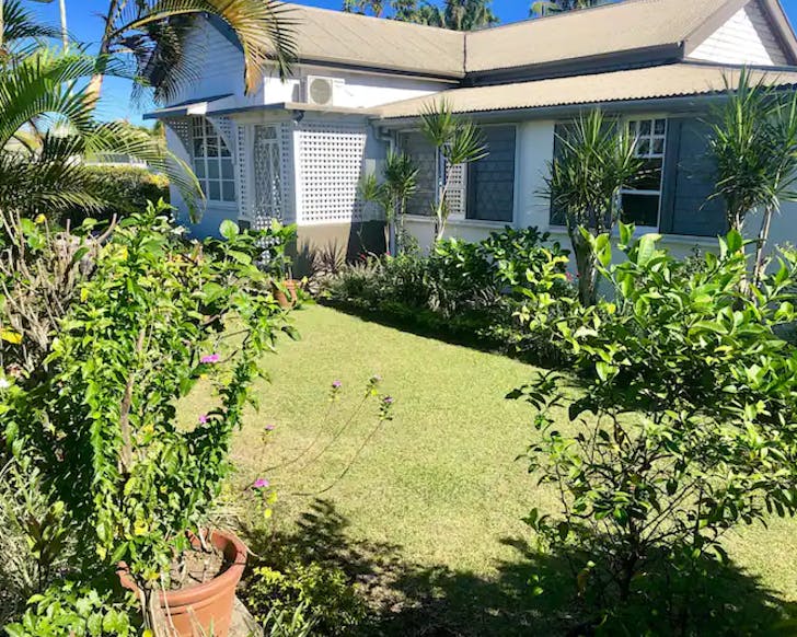A lush garden wraps around The Denison Cottage, one of the best Airbnbs in Fiji. 
