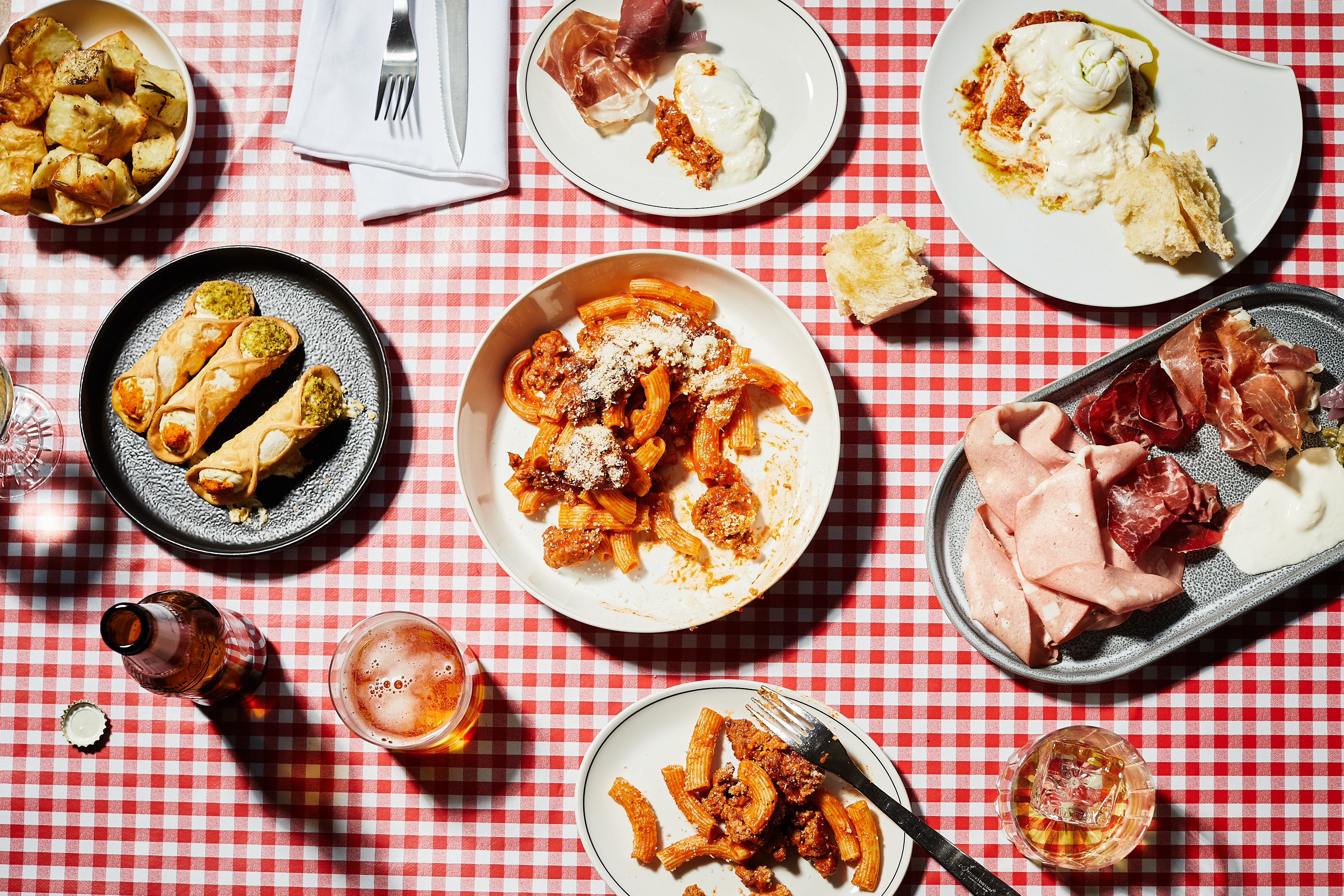 A top-down view of a classic Italian feast on top of a tartan table cloth.