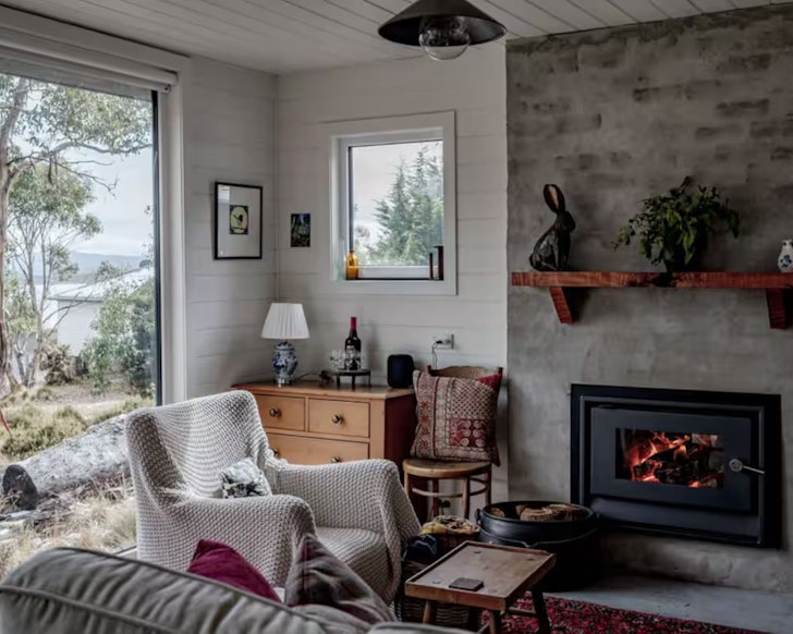 The cosy indoor fire in the living space with a lake view at The Highland Shack one of Tasmania's best lake houses