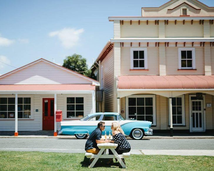 A couple enjoys bottles of soda outside The Historic Village. 