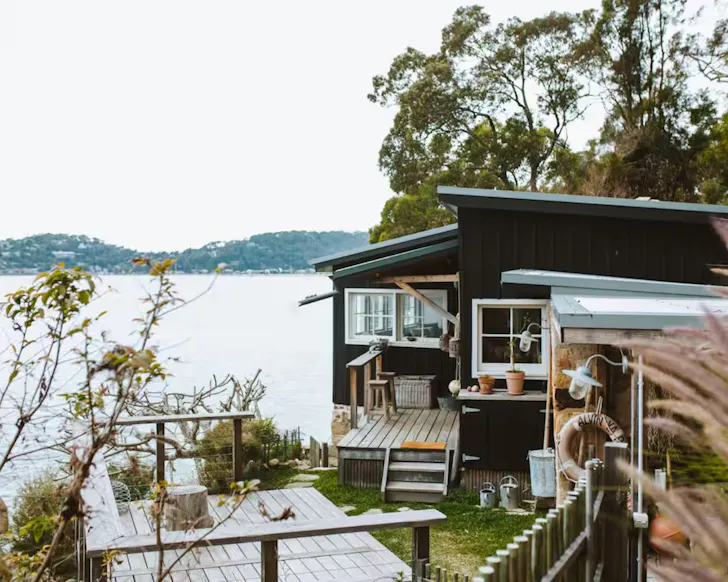 An exterior view of the The Little Black Shack on the water, some of the best Central Coast accommodation