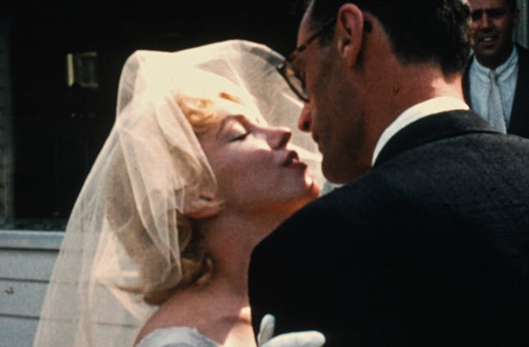 Marilyn Monroe leans in for a kiss on her wedding day.