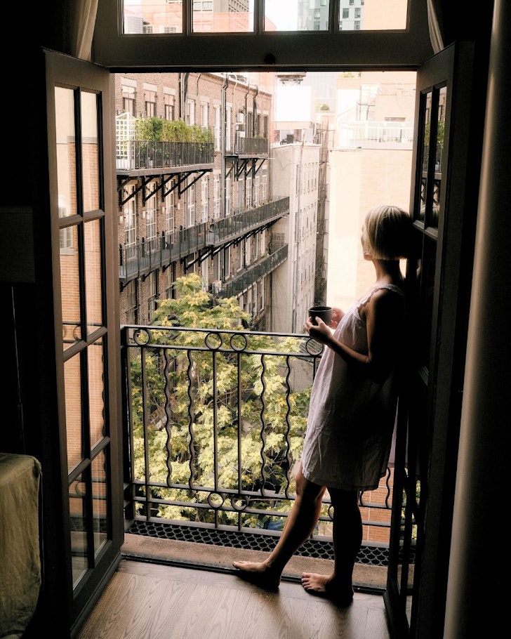 A woman on a room balcony at The Mercer best hotels Soho New York
