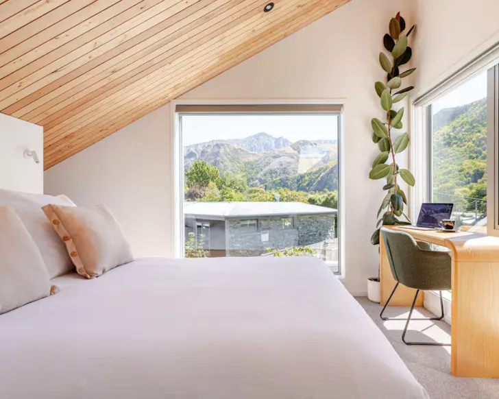 The bedroom at the Miners Hut romantic stay near Queenstown, New Zealand, with a view of the landscape 