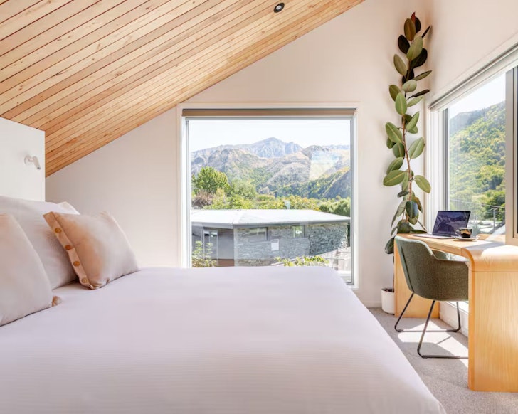 The bedroom at the Miners Hut romantic stay near Queenstown, New Zealand, with a view of the landscape 