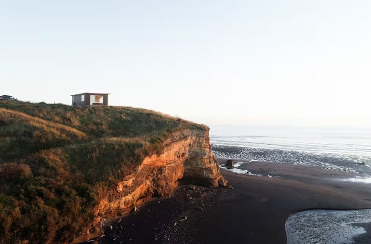 A view of The Nest cosy cabin in New Zealand perched on a cliff top