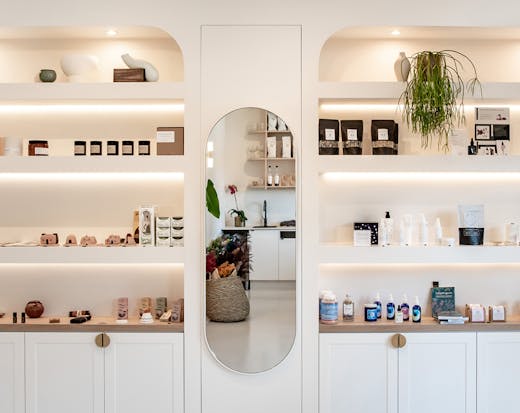 White custom-made shelves are stocked with beauty and wellness products at new Noosa store, The Orangerie.