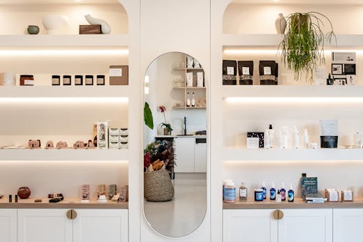 White custom-made shelves are stocked with beauty and wellness products at new Noosa store, The Orangerie.